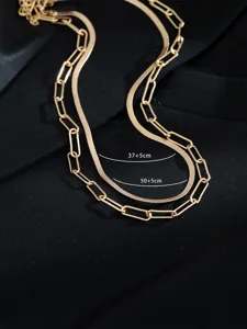 Dettaglio collana doppia dorata, elegante design a catena serpentina e graffetta.