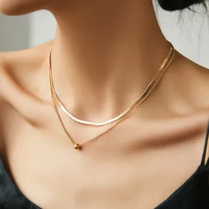 Primo piano di una collana a doppio strato minimalista con catena a serpente e perla.