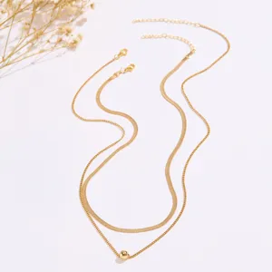Primo piano dettagliato della collana a catena di serpente dorata multistrato con ciondolo.