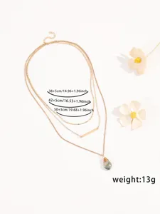 Collana con ciondolo dorato multistrato con dettaglio in pietra naturale e lunghezza regolabile.