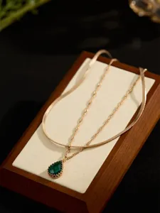 Elegante collana multistrato dorata caratterizzata da uno splendido ciondolo verde.