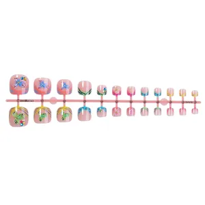 Detailed view of short press-on toenails featuring tropical flowers, rhinestones and style.