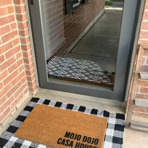 Gelaagde deurmat detail, zwart wit ruitjes tapijt met kokosnoot entree mat