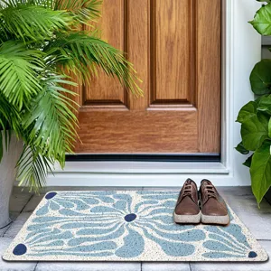 Detail view of Nordic style entrance door mat with blue floral pattern at home doorway.