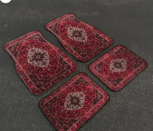 Detailed view of vintage Persian rug style car floor mats, showing intricate red patterned texture.