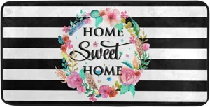 Detailed view of floral kitchen rug featuring black and white stripes and sweet home text
