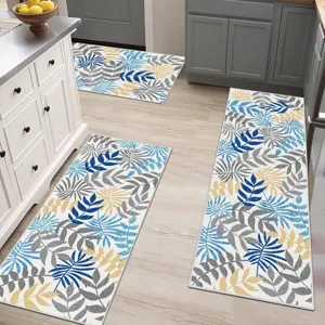 Detailed view of kitchen floor mats with blue and yellow botanical leaf pattern in modern kitchen.