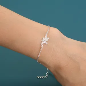 Detaillierte Nahaufnahme des silbrigen Gecko-Anhängerarmbands stilvoll am Handgelenk.