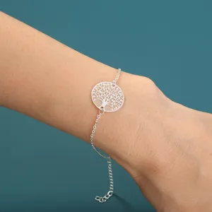 Nahaufnahme des silberfarbenen, leuchtenden Lebensbaum-Armbanddetails am Handgelenk getragen.