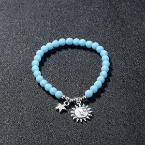 Detailaufnahme des hellblauen Perlenarmbands mit silbernen Stern- und Sonnenanhängern.