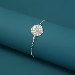 Detailansicht des leuchtenden runden Armbands mit filigranem Muster auf blauem Hintergrund