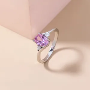 Primo piano dettagliato dell'elegante anello in zircone rosa con pietre laterali brillanti.