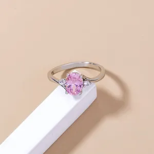 Primo piano dettagliato di elegante anello in argento con zircone rosa ovale e pietre.