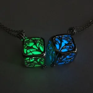 Dettaglio del ciondolo collana albero della vita luminoso con splendida luce verde e blu al buio.