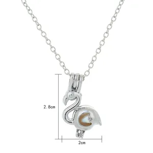 Silver tone flamingo cage pendant necklace detail, featuring pearl locket and clear size.