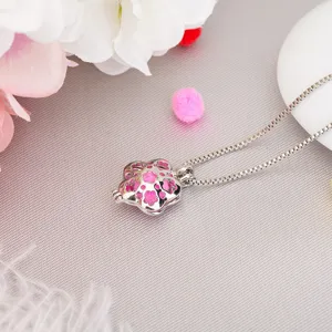Silver aromatherapy locket necklace detail, delicate hollow flower pendant with pad.