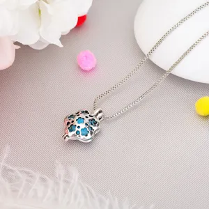 Detailed view of silver hollow aromatherapy ball pendant necklace, retro DIY style jewelry part.