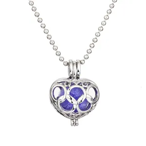 Detail view of the hollow heart locket necklace with a vibrant aroma ball inside.