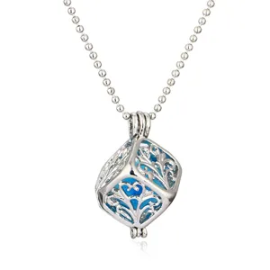 Detailed view of vintage hollow aromatherapy ball pendant necklace with blue glowing core.