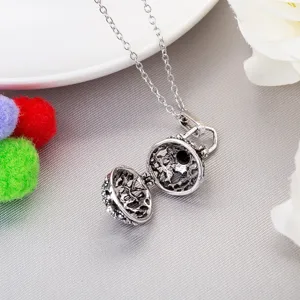 Vintage hollow aromatherapy ball pendant necklace with delicate chain, elegant fashion jewelry.