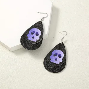 Halloween Ohrringe mit doppelten Tropfen und lila Totenkopfmustern auf schwarzem Glitzer.
