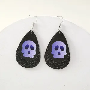 Halloween Totenkopf Tropfen Leder Ohrringe mit Glitzer Design und silbernen Haken.