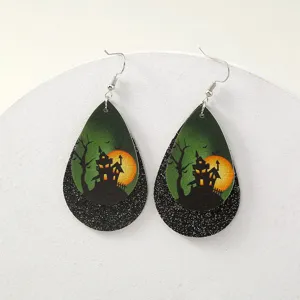 Nahaufnahme von Halloween Tropfenohrringen mit Schloss Motiv und glitzernder schwarzer Schicht.