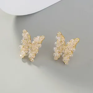 Close-up view of delicate crystal beaded butterfly earrings featuring intricate gold wire wrapping.