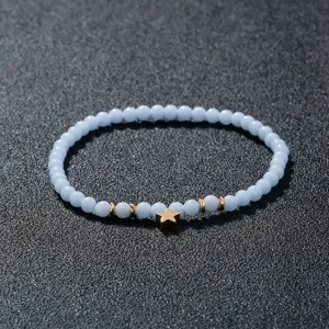 Detailansicht des hellblauen Perlenarmbands mit goldenem Sternanhänger und Metallabstandshaltern.