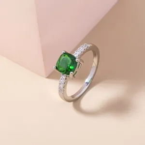 Dettaglio dell'anello con pietra verde quadrata e pavé di zirconi bianchi luminosi.