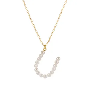 Primo piano della collana con ciondolo lettera perla catena dorata dal design dettagliato.