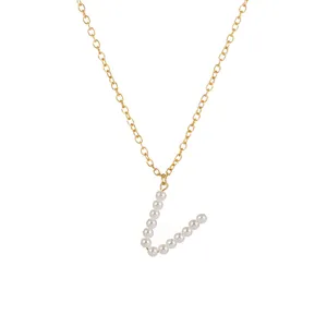 Primo piano della collana con ciondolo lettera V in perle, dettagli catena dorata.