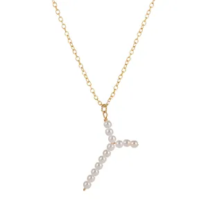 Primo piano dell'elegante collana con catena in oro e ciondolo a lettera Y con perle.