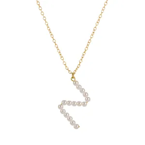 Elegante collana con catena dorata e ciondolo lettera di perle, gioiello minimalista.