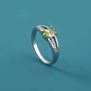 Vista dettagliata di anello donna con zircone giallo ovale e pietre bianche microincastonate.