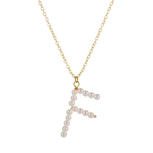 Dettaglio della collana con catena placcata in oro e ciondolo di perle lettera F.