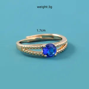 Anello regolabile color oro con zircone blu vibrante e delicati dettagli con perline.