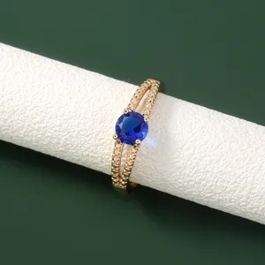 Squisito anello in rame placcato oro con una brillante pietra centrale in zircone blu.