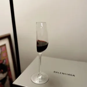 Detail shot of a creative half wine glass with red liquid, unique optical illusion design.