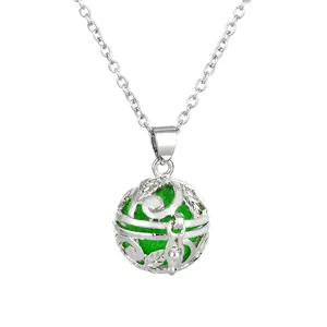 Detailed view of silver hollow aromatherapy ball pendant necklace with green inner sphere.