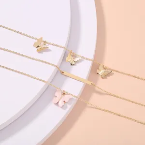 Vista detallada de la pulsera multicapa con dijes de mariposa y cadena dorada rosa.