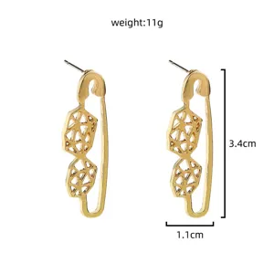Gold safety pin geometric earrings detail, minimalist metal design, lightweight drop style.