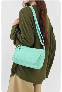 Detailaufnahme der leichten Nylon-Umhängetasche für Damen in Mintgrün, mit vielen Fächern.