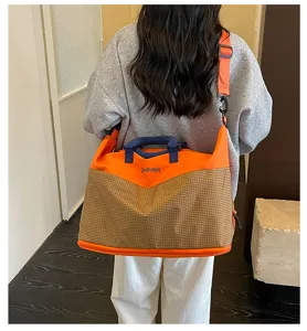 Grand sac de voyage fourre-tout montrant le détail du dos en orange et carreaux.