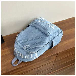 Washed denim backpack for women, large capacity casual school bag with star embroidery. Detail view.