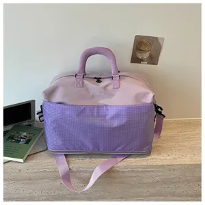 Vue detaillee du sac de voyage violet de grande capacite, mettant en valeur le tissu.