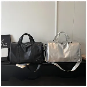 Detailed view of large capacity soft leather travel duffel bag in black and silver.