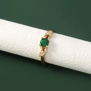Detailopname van een gouden ring met een groene edelsteen en delicate micro-zet accenten.