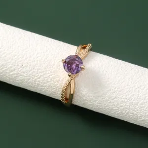 Close-up van de elegante delicate vergulde ring met een sprankelende paarse zirkonia.