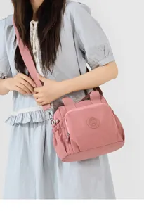 Vue détaillée du sac bandoulière en nylon pour femme, sac à main rose multicouche.